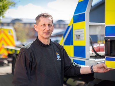 Male mechanic standing next to recovery vehicle