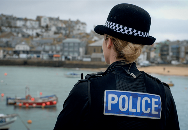 The back of a female officer looking at a harbour view