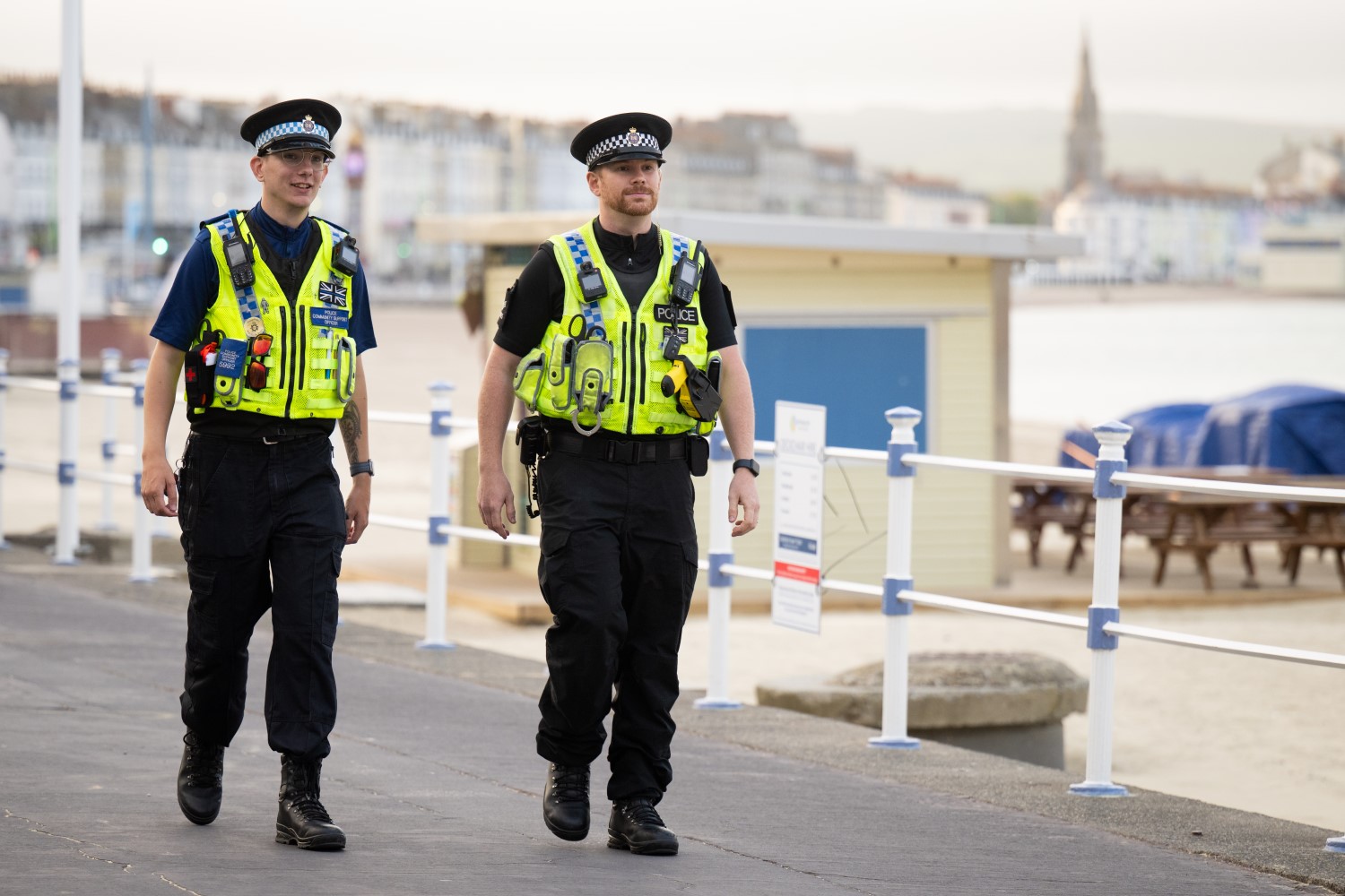 Two male officers walking along the seafront