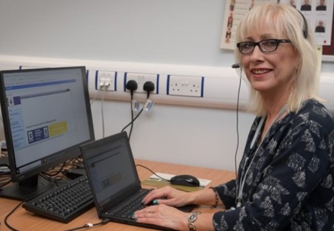 Smiling female police staff member sat at desk