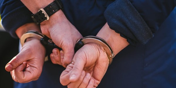 Hands in handcuffs behind their back