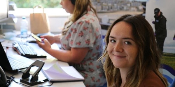 Smiling at camera while sat at desk