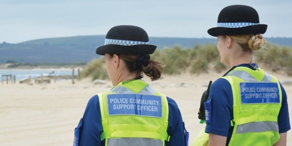 Two PSCO's looking at a sandy beach on a fine summers day