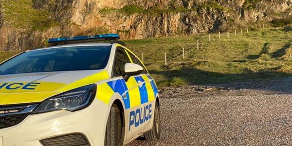 A police car parked up in a coastal car park